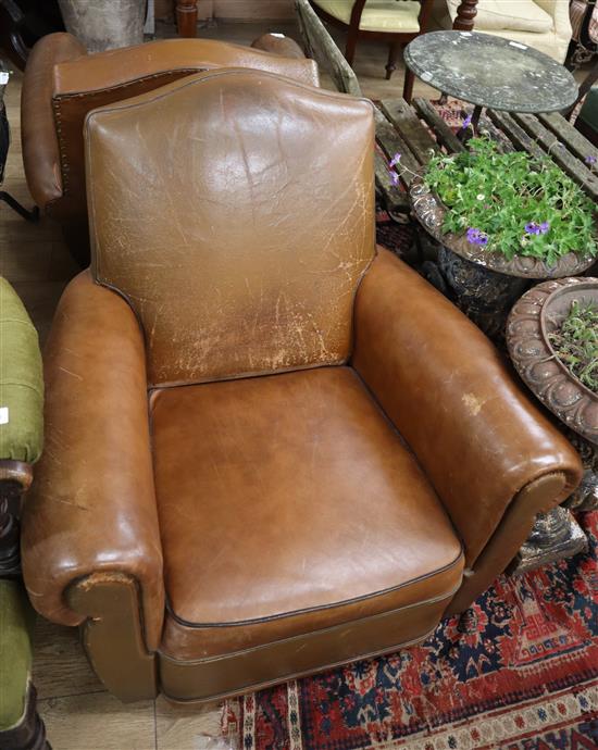 A pair of brown leather club armchairs